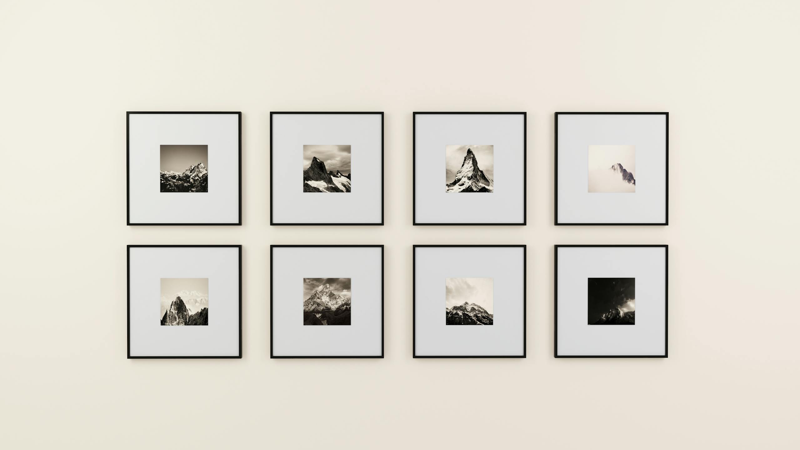 A minimalist display of framed mountainsdfgdgsdfdf photography on a plain wall.